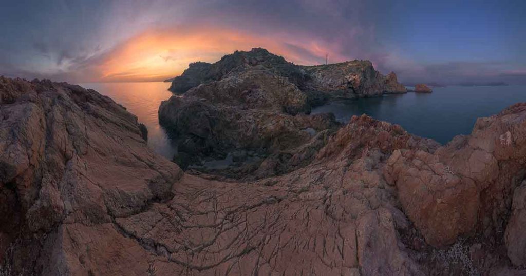 Paisaje costero de Murcia con acantilados y aguas cristalinas, capturado con una narrativa visual oscura y cinematográfica.